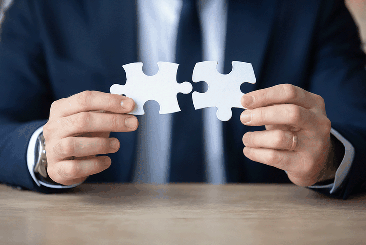 Ilustračná fotografia - ruky držia dve časti puzzle