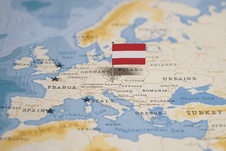 Mapa Európy so zapichnutou vlajkou na území Rakúska