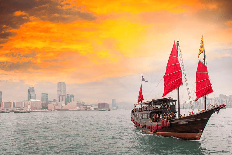 Ilustračná fotografia - loď na morí, na pozadí obrysy veľkomesta